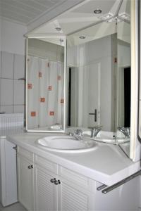 沃尔姆斯Herrenhof的浴室配有白色水槽和大镜子