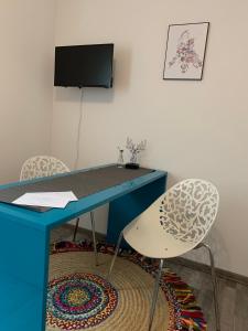 FrensdorfSüßes Zimmer im Souterrain的一张带两把椅子的蓝色书桌和一台电视