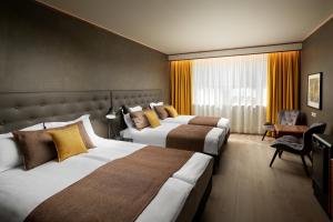 雷克雅未克Hotel Ísland – Spa & Wellness Hotel的酒店客房,配有两张床和椅子