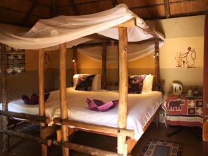 马翁Discovery Bed and Breakfast的卧室配有带白色床单的木制天蓬床