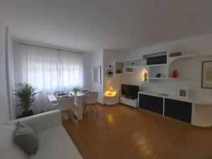 厄尔梅达诺A&A El Médano Apartment AIRE, WIFI, CANALES TV的客厅配有白色的沙发和桌子