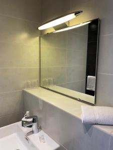 图尔科尔伯特酒店的一间带镜子和水槽的浴室