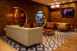 马拉巴INACIO'S PLAZA HOTEL的大堂配有沙发、椅子和电视