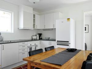斯特伦斯塔德Holiday home STRÖMSTAD XVIII的厨房配有木桌和白色冰箱。