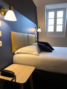 图尔科尔伯特酒店的一间卧室配有一张带桌子和窗户的床