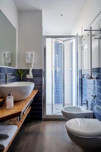 里米尼麦迪逊酒店的一间带两个水槽和玻璃淋浴间的浴室