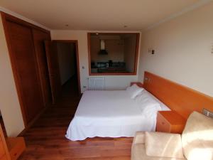 格罗韦Apartamentos Ay Sálvora的卧室配有白色的床和沙发