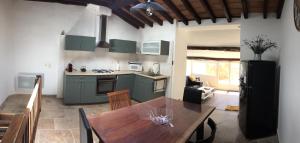 戈尔德Chez Marius Gordes Vue panoramique sur luberon的厨房以及带木桌的用餐室。