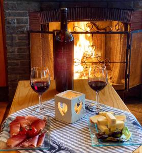 克莱恩 蒙塔纳爱德多酒店的一张桌子,上面放着两杯红葡萄酒和奶酪