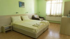 茨雷沃Guest House Gardeli的一间卧室配有一张床和一把椅子