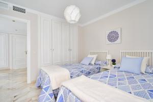 马拉加Apartamento Málaga City Beach的蓝色和白色的客房内的两张床