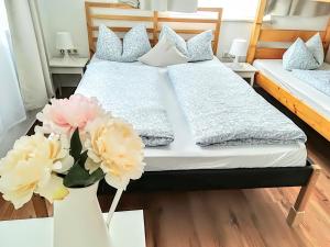 福森House LA Neuschwanstein Blick的一间卧室配有两张床,桌子上放着鲜花