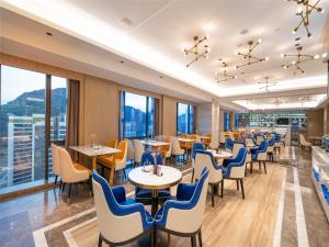 贵阳Kyriad Marvelous Hotel Guiyang Future Ark的餐厅设有桌椅和窗户。