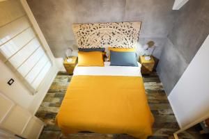 罗马Rosso Cortese的一间卧室配有一张带黄色床单和黄色枕头的床。