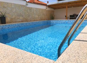 扎达尔Villa Sanda with Private Pool的一座带秋千的蓝色游泳池