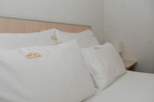 大格拉迪什泰Sobe Alex的白色的床、白色枕头和木制床头板