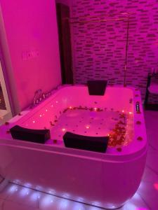 哈费尔巴廷Al Hreer Hotel的客房内的粉红色浴缸配有灯