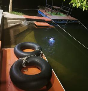 班康卡臣碧差汶府河小屋旅馆的两辆黑色轮胎坐在水中的船上