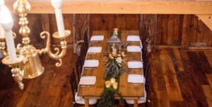 AndoverHighland Lake Inn的用餐室配有长桌子和白色椅子