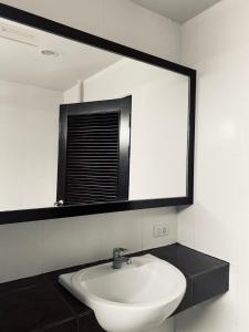 奥南海滩J酒店的浴室设有白色水槽和镜子