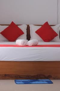 达瓦拉维Cassia Udawalawe的一张带红色和白色枕头的床