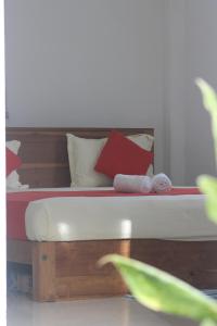 达瓦拉维Cassia Udawalawe的一张带红色和白色枕头的床