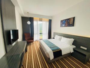 峇都丁宜Bahang Bay Hotel的酒店客房,配有床和电视