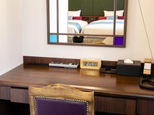东京Hotel Wing International Select Ikebukuro的一张带镜子的桌子和一张位于客房内的床