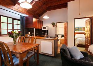 比勒陀利亚Waterkloof Apartments的厨房以及带桌椅的用餐室。