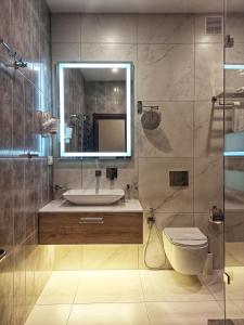 哈尔科夫维瓦酒店的一间带水槽、卫生间和镜子的浴室