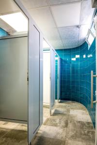 克尔贾利Hostel Kyosheto的走廊上设有蓝色瓷砖墙壁和玻璃门
