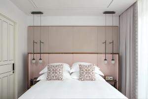 特拉维夫诺曼特拉维夫酒店的卧室配有一张带两个枕头的大白色床