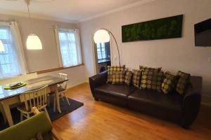 路德维希堡Wohnung im Herzen von Ludwigsburg的客厅配有黑色沙发和桌子