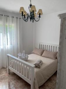 圭哈尔谢拉Casa Vista Nevada的卧室配有白色的床和吊灯。