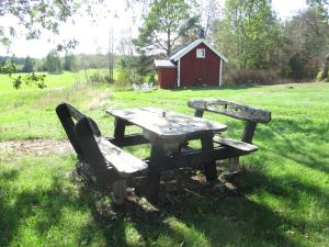 斯特伦斯塔德Stuga vid viltåker nära norska gränsen的野餐桌和红色谷仓的长凳