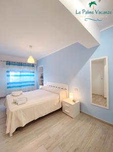 特拉佩托Le Palme Vacanze的白色卧室设有一张大床和镜子