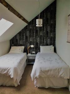 VieillevilleEen prachtige Gîte in Frankrijk Chez Gerard的一间卧室设有两张床,天花板上设有窗户。