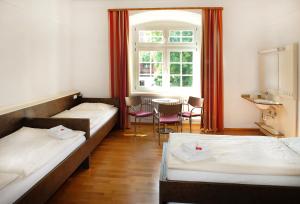 洛特安德洛特圣诺伯特青年旅舍的客房设有两张床、一张桌子和一扇窗户。
