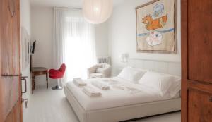 圣阿尔坎杰洛-迪罗马涅DelleFarfalle Boutique Apartments的白色卧室配有白色的床和红色椅子