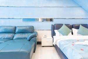 广州广州市铂宫阳光国际酒店公馆（北京路金润铂宫店）的蓝色的客房配有一张沙发和一张床