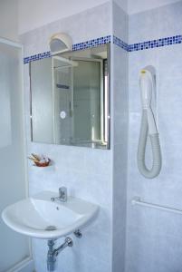 利多克拉西Hotel Mirage的白色的浴室设有水槽和镜子