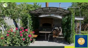 叶海格纳佐尔Guest house Hasmik的玫瑰拱下花园,花园内有长凳