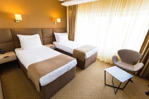 布加勒斯特水晶宫酒店的酒店客房,配有两张床和椅子