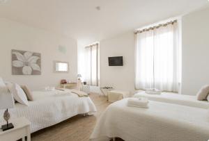 斯培西亚卡萨戴纳酒店的白色卧室配有2张带白色床单的床
