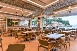 乌尔齐尼Plaza Hotel&SPA的一间带桌椅的海景餐厅