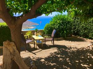 ThólosLuxus Tholos Bay的树下桌椅,享有海景