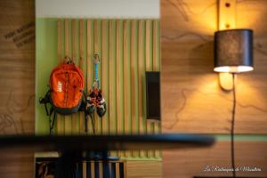穆斯捷-圣玛丽厄斯特克姆斯特酒店的挂在灯旁墙上的橙色背包