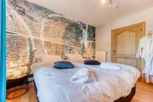HaletLe Domaine de Wisbeley的卧室配有带蓝色枕头的大型白色床