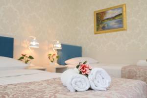 卢布尔雅那Boutique Hotel Asteria的酒店客房的床上配有2条毛巾