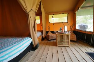 BockholtzSafaritent op Camping Berkel的一间卧室配有一张床,帐篷内配有一张桌子